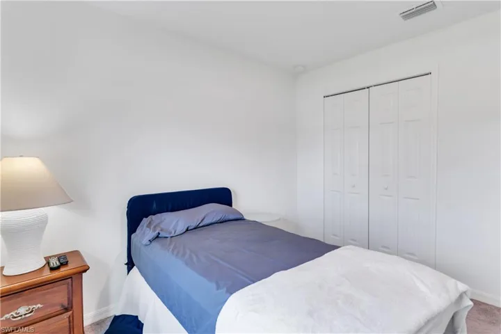 Carpeted bedroom with a closet
