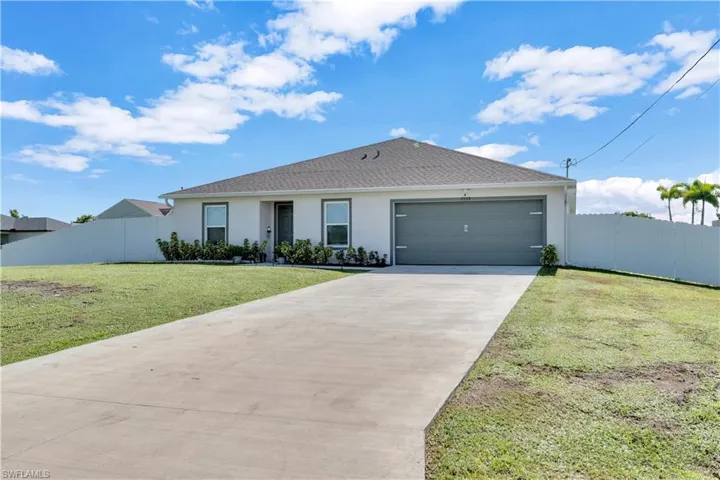 Single story home with a front yard and a garage