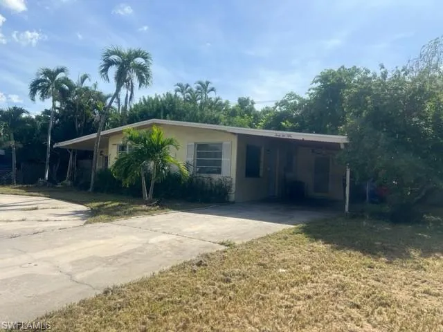 View of front of house featuring a carport and a front yard