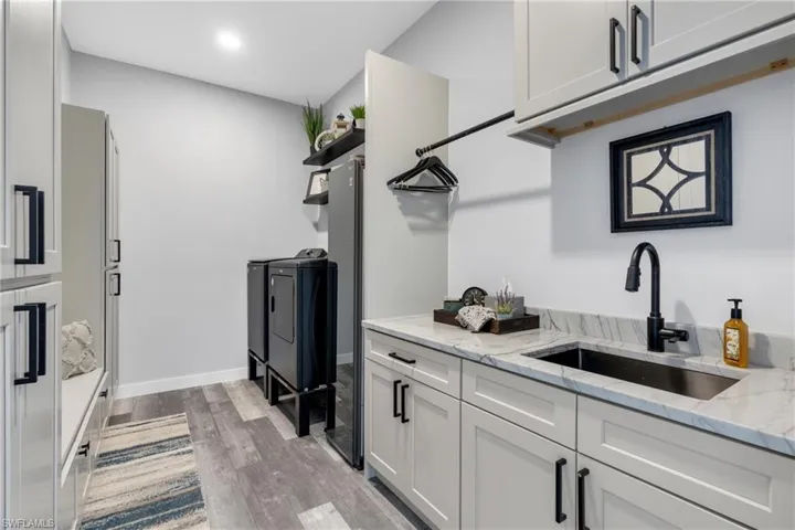 Laundry room with storage and upright steamer and sink