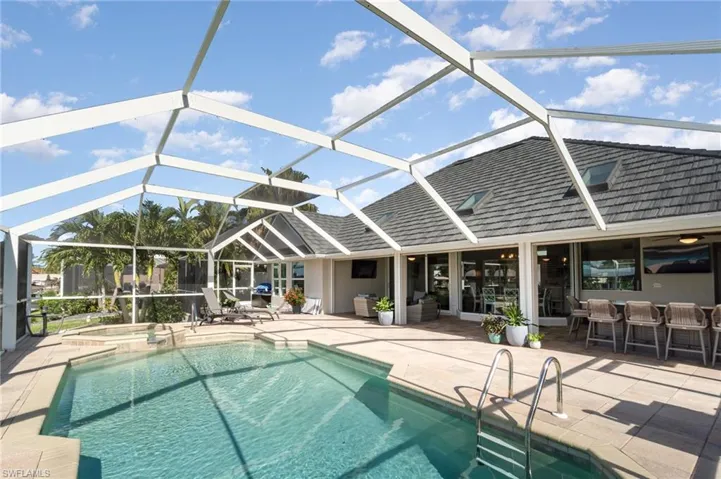 View of pool with a patio area and screen enclosure
