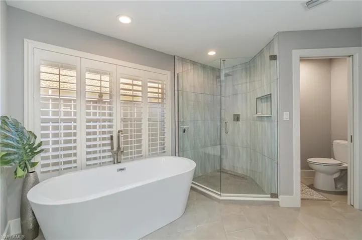 Bathroom with toilet, tile patterned floors, and independent shower and bath
