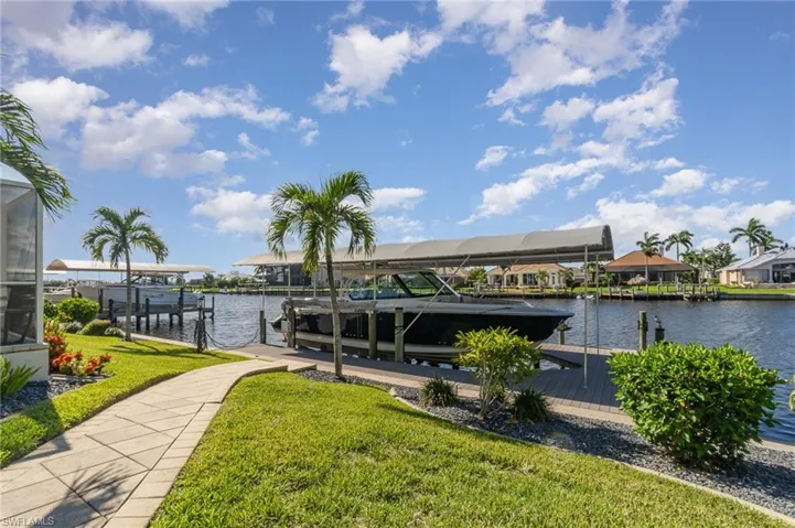 Dock area featuring a water view and a lawn