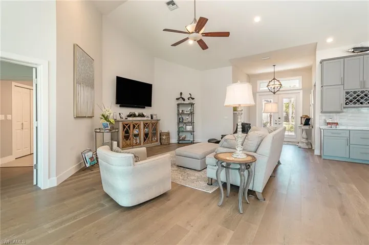Living room with a towering ceiling, light hardwood / wood-style flooring, and ceiling fan