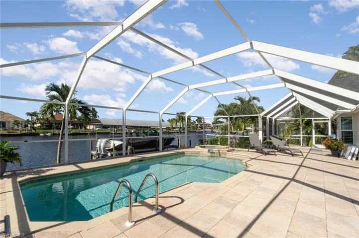 View of pool with a patio area, a water view, and a lanai