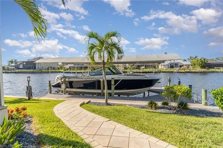 View of dock featuring a yard and a water view