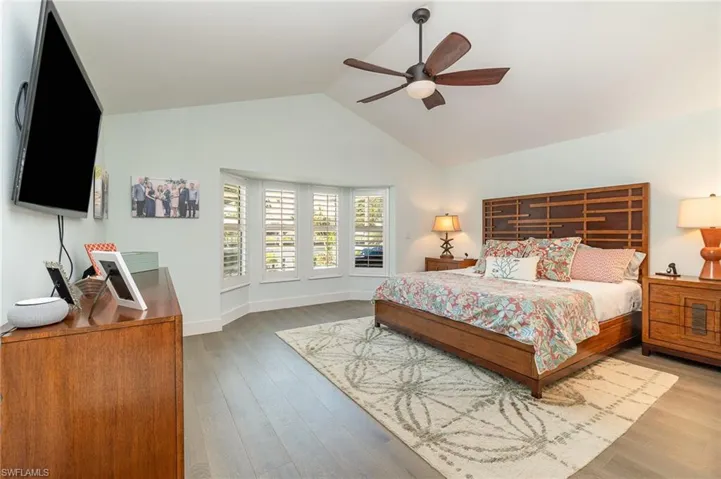 Bedroom featuring vaulted ceiling, light wood-type flooring, and ceiling fan