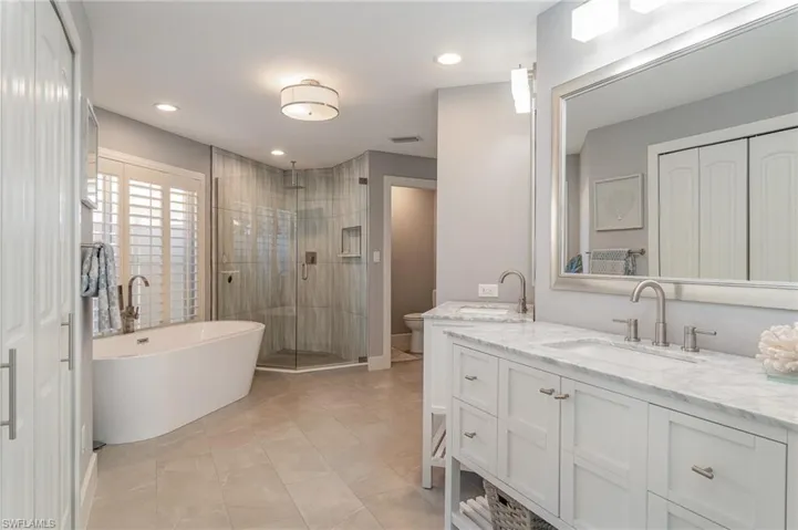 Full bathroom featuring vanity, toilet, tile patterned floors, and plus walk in shower