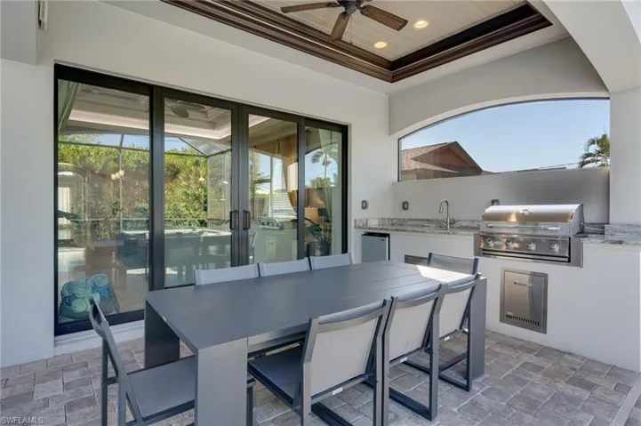 View of patio with an outdoor kitchen / dining area and a ceiling fan