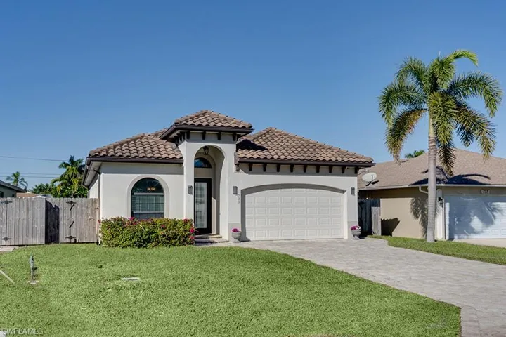 Mediterranean / spanish-style house featuring decorative driveway, stucco siding, a garage, and a gate