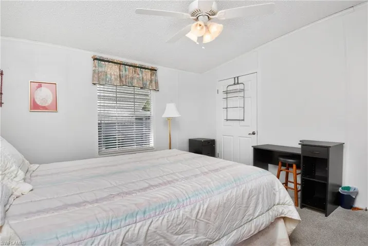 Carpeted bedroom with a ceiling fan