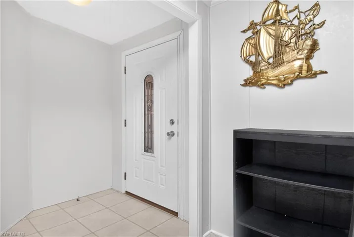 Foyer with light tile patterned flooring