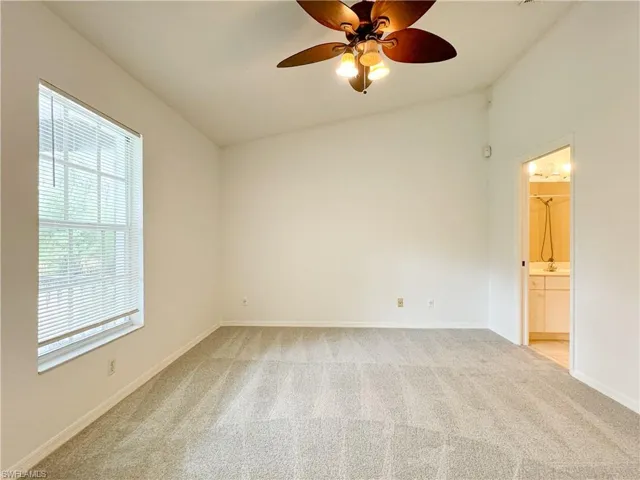 Carpeted empty room featuring ceiling fan