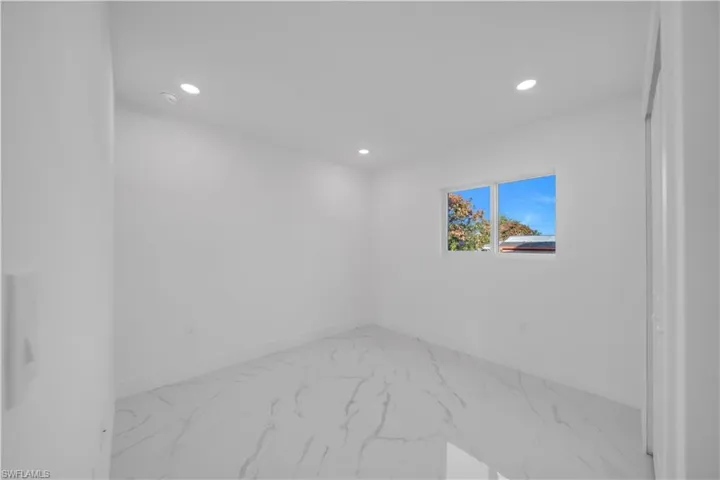 Empty room featuring recessed lighting and light marble finish flooring