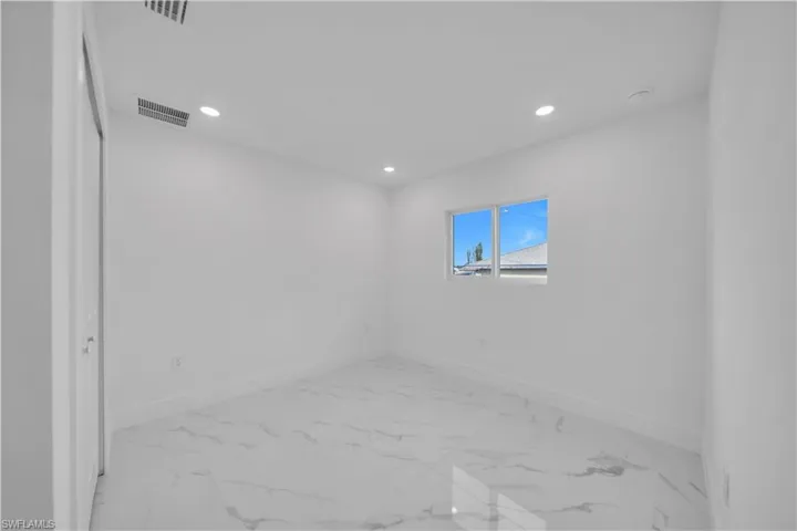 Unfurnished room with recessed lighting and light marble finish floors