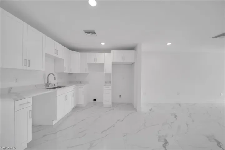 Unfurnished bedroom with recessed lighting, a closet, and light marble finish floors