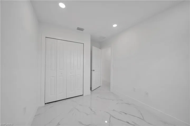 Unfurnished bedroom with recessed lighting, a closet, and light marble finish flooring