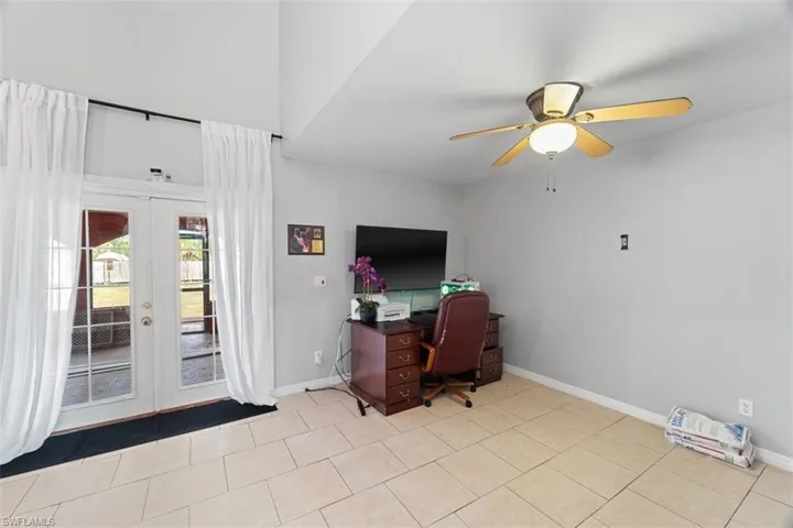Tiled office space featuring ceiling fan and french doors