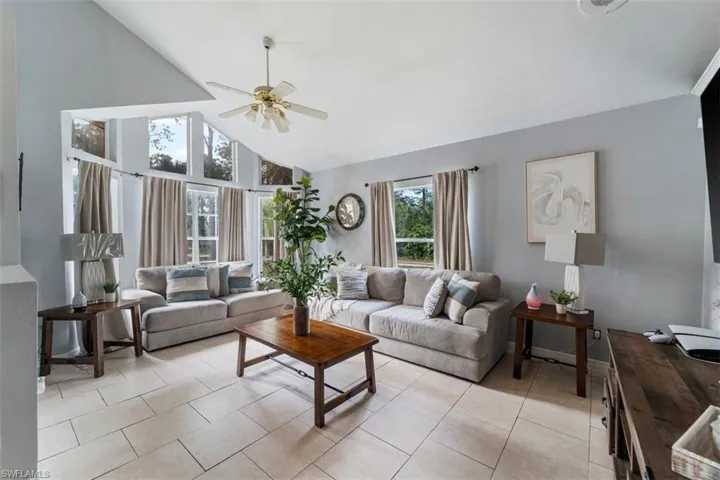 Tiled living room featuring high vaulted ceiling and ceiling fan