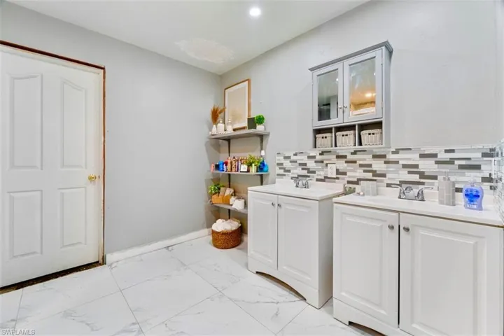 Bathroom featuring vanity and backsplash