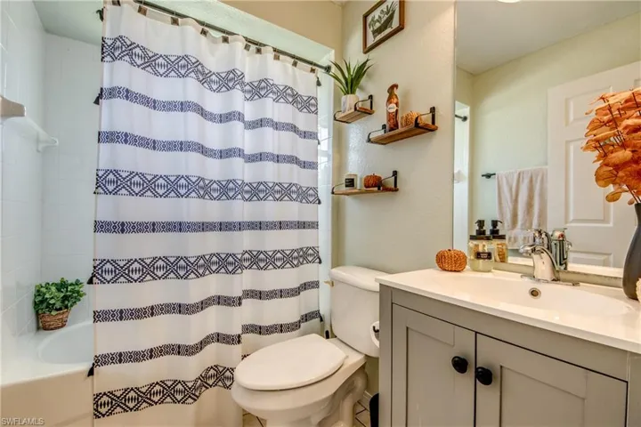 Bathroom featuring shower / bath combo with shower curtain and vanity