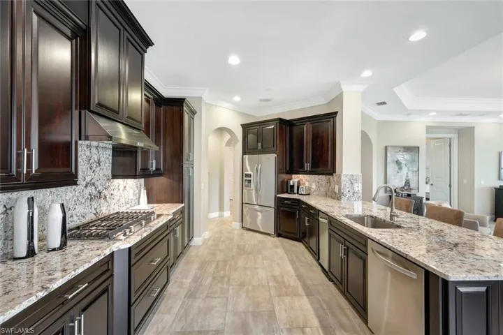 Kitchen with sink, a kitchen breakfast bar, decorative backsplash, and appliances with stainless steel finishes