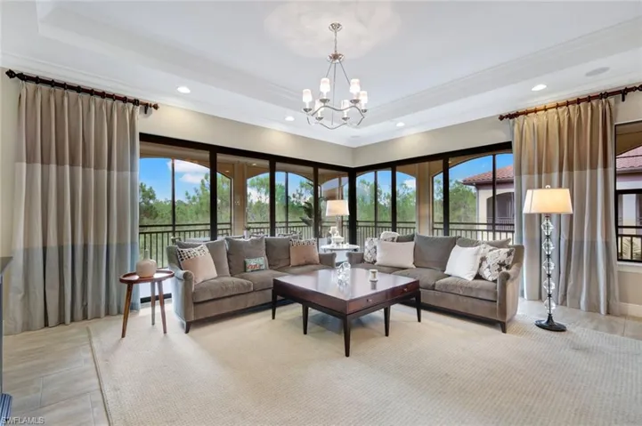 Living room with a raised ceiling and an inviting chandelier