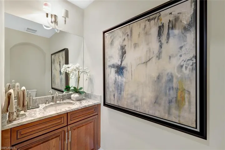 Bathroom featuring vanity, a notable chandelier, and toilet