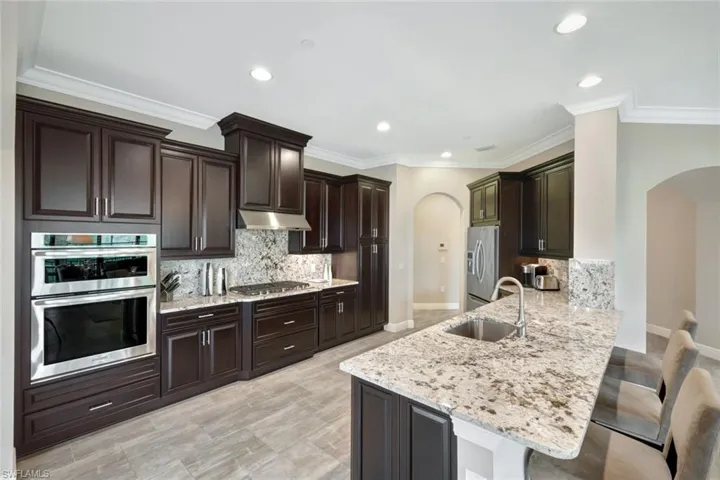 Kitchen featuring sink, kitchen peninsula, backsplash, and stainless steel appliances