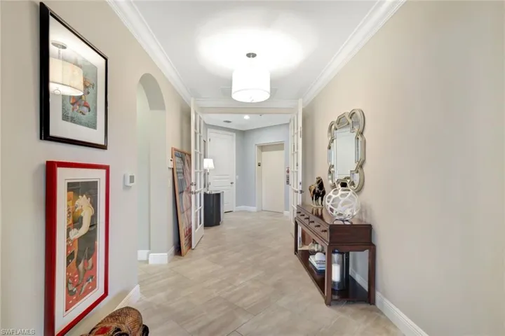 Entrance featuring private elevator ornamental molding and light tile patterned floors