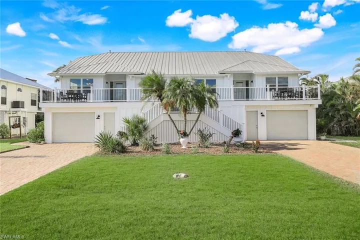 View of front of house with a front lawn, a porch, and a garage