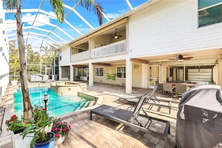 View of pool featuring grilling area, ceiling fan, a lanai, an in ground hot tub, and a patio