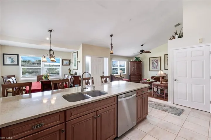 Kitchen featuring dishwasher, hanging light fixtures, lofted ceiling, and sink
