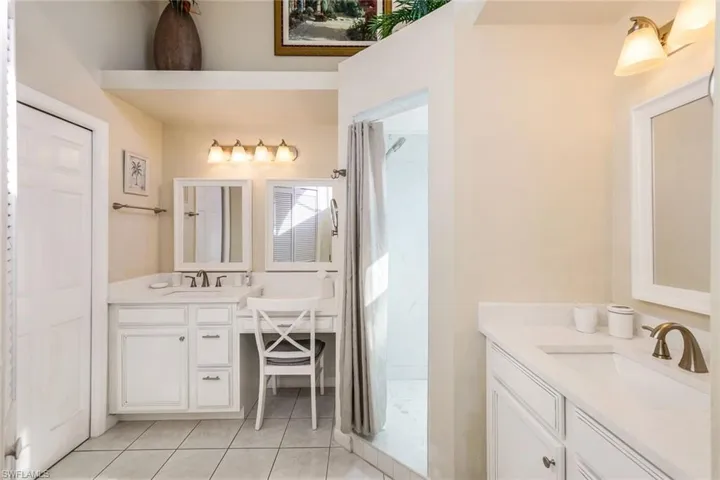 Bathroom featuring curtained shower, tile patterned flooring, and vanity