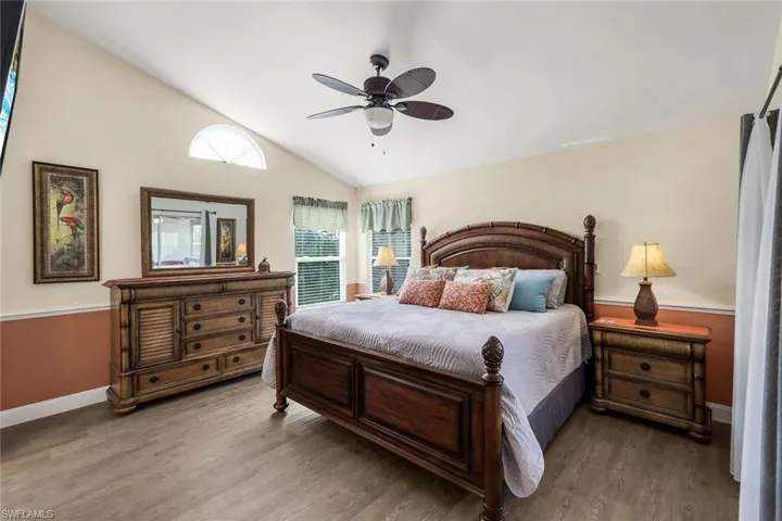 Bedroom featuring ceiling fan, lofted ceiling, and light wood-type flooring
