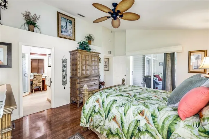Bedroom featuring ceiling fan, dark hardwood / wood-style flooring, lofted ceiling, and access to outside