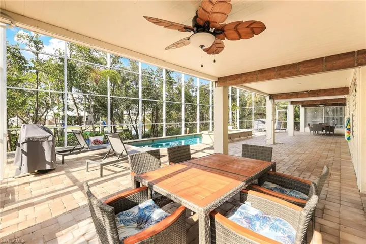 Sunroom / solarium with ceiling fan and a swimming pool