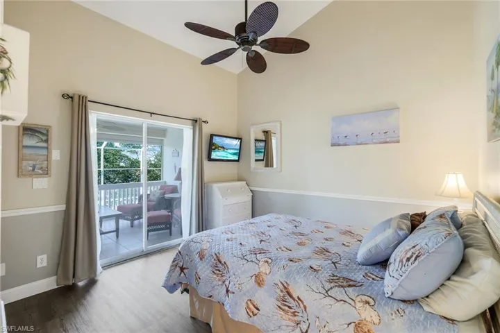Bedroom featuring access to outside, ceiling fan, high vaulted ceiling, and hardwood / wood-style flooring