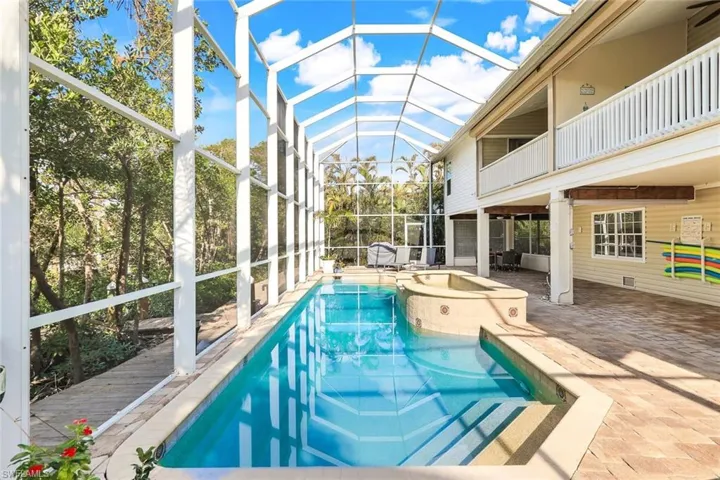 View of swimming pool featuring a lanai, a patio area, and a hot tub