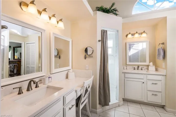 Bathroom with tile patterned floors, vanity, and a wealth of natural light