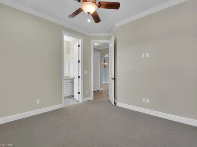 2nd ground floor guest with on suite bath room featuring crown molding, ceiling fan with notable chandelier, and light carpet