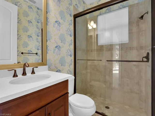 Ground floor guest bath Bathroom with walk in shower, vanity, and toilet