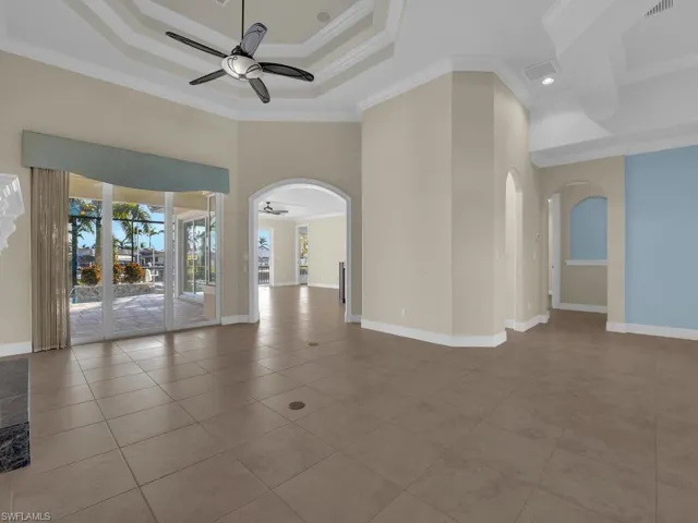 Living Room with ceiling fan, ornamental molding, a raised ceiling, and a towering ceiling