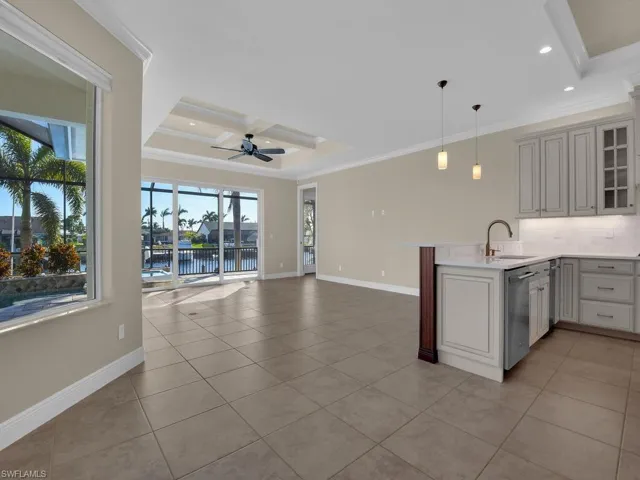 Kitchen with dishwasher, a water view, ornamental molding, decorative light fixtures, and kitchen peninsula