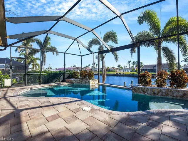 View of pool featuring a water view, a lanai, pool water feature, and a patio area