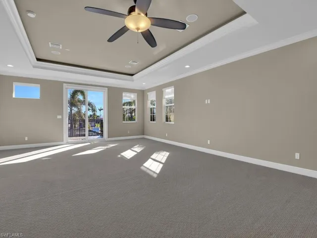 Media/Entertainment/Mancave room with ornamental molding, ceiling fan, and a tray ceiling