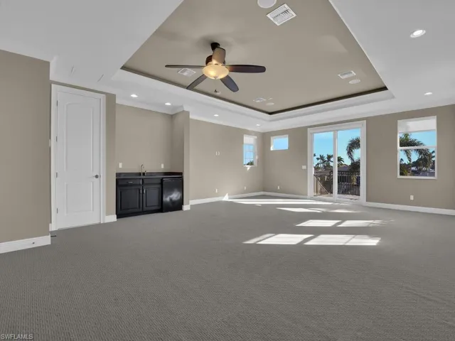 Media/Entertainment/Mancave room with ceiling fan, a tray ceiling, and carpet floors