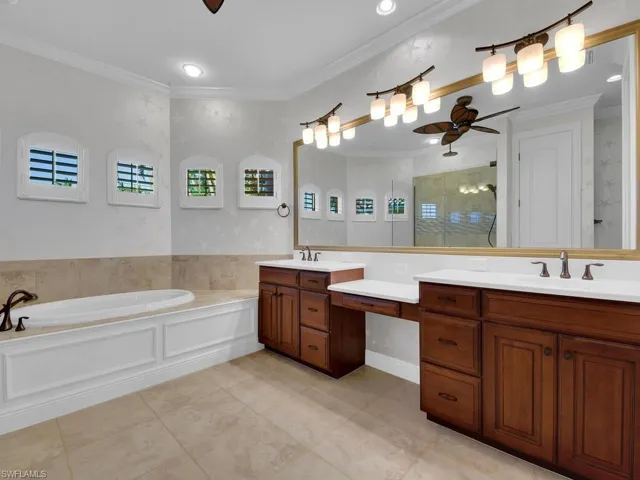 Master Bathroom featuring crown molding, separate shower and tub, vanity, ceiling fan, and tile patterned flooring