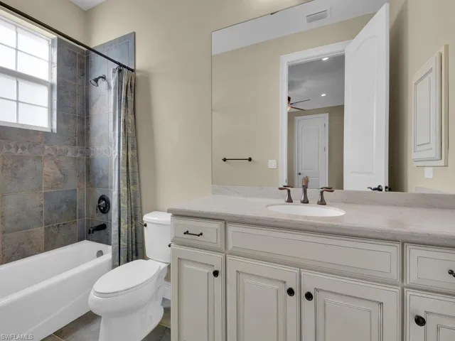 2nd guest room full bathroom with vanity, shower / tub combo with curtain, and toilet
