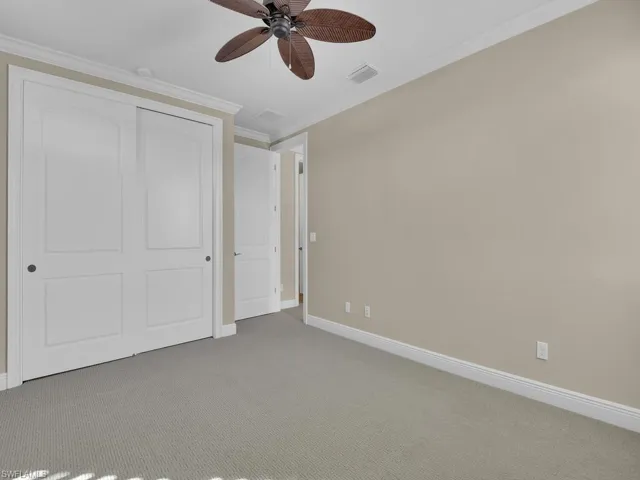 3rd guest room bedroom featuring crown molding, a closet, ceiling fan, and carpet